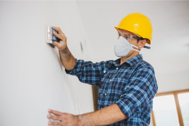 Costa Mesa Worker Sanding a drywall